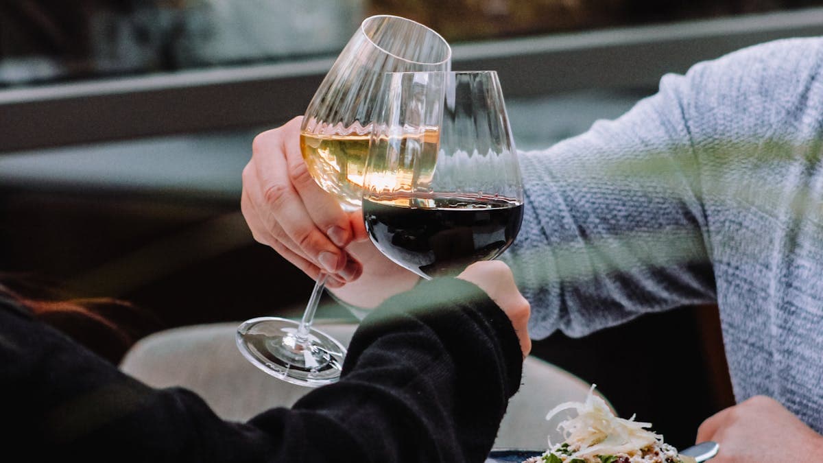 Couple clinking wine glasses over a plate of food at an elegant outdoor restaurant brunch in Orlando