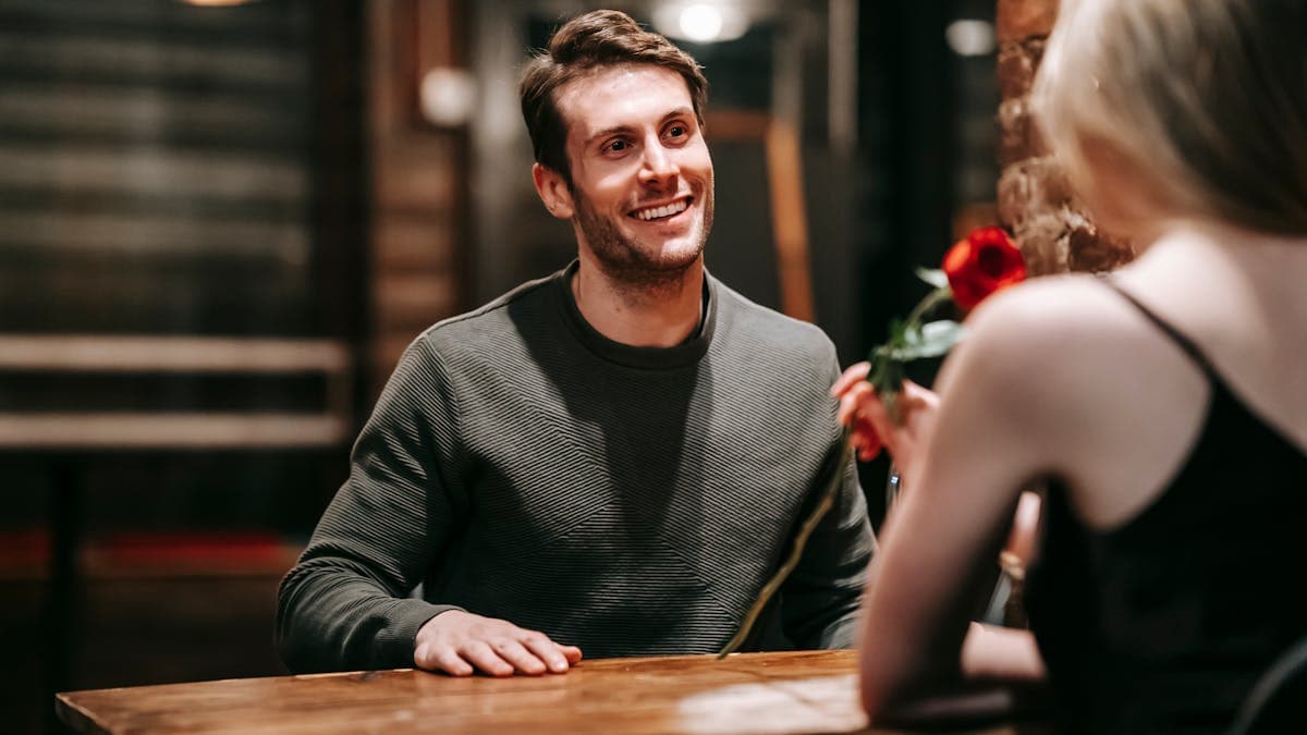 Happy couple smiling and sharing a romantic moment at a cafe table during a first date in Orlando